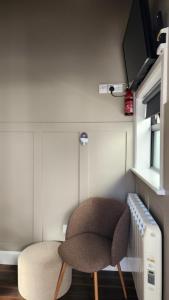a small room with a chair and a heater at Urban Nest Townhouse in Galway