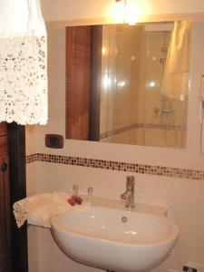 een badkamer met een witte wastafel en een spiegel bij Marilyn in Laterza