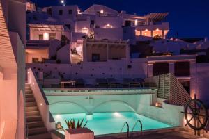 Villa con piscina por la noche en On The Rocks - Small Luxury Hotels of the World, en Imerovigli