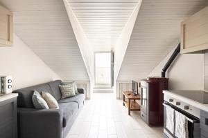 a living room with a gray couch in a kitchen at Uno Due Tre Stella in Chioggia