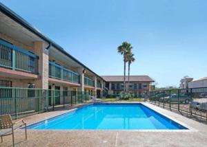 a large swimming pool in front of a building at Budgetel Inn Houston/Nasa in Webster