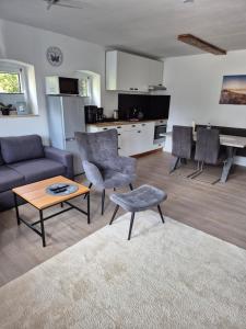 a living room with a couch and chairs and a table at Thirty Minutes in Ellingstedt