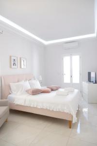 a white bedroom with a large bed and a couch at Modern Sea-View Maisonette in Spetses for 6 people in Spetses