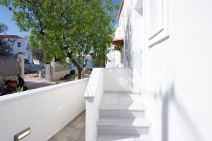 a white staircase in a white house with a tree at Modern Sea-View Maisonette in Spetses for 6 people in Spetses