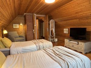 a bedroom with two beds and a flat screen tv at Sarapuu puhkemaja in Hullo