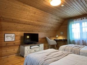 a bedroom with two beds and a flat screen tv at Sarapuu puhkemaja in Hullo