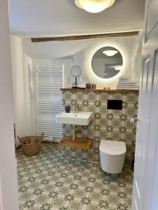 a bathroom with a sink and a toilet and a mirror at Wohlfühlen & Entdecken in der barocken Altstadt in Blieskastel