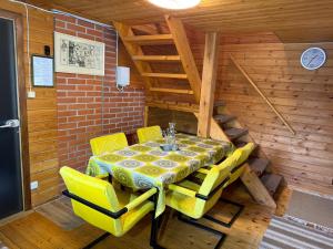 a dining room with a table and yellow chairs at Sarapuu puhkemaja in Hullo