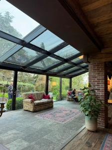 a conservatory with a glass roof with people sitting at Locanda Maison Verte in Cantalupa