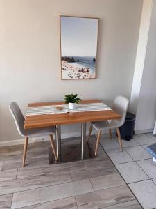 a dining room table and chairs with a picture on the wall at Ekaya in Fremantle