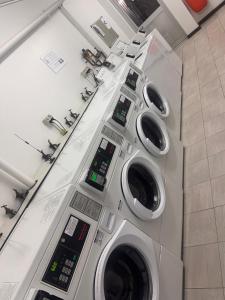 a row of four washing machines in a bathroom at Ekaya in Fremantle