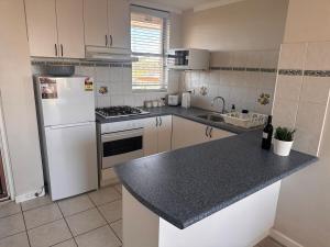 a kitchen with white appliances and a black counter top at Ekaya in Fremantle
