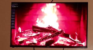 a television with a fire in a brick fireplace at Baobab in Webuye