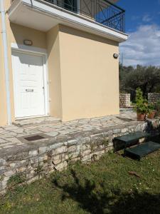 a white door on the side of a house at Studio with cute garden space in Nydri