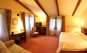 a hotel room with a bed and a desk and a table at Locanda Maison Verte in Cantalupa +73 photos