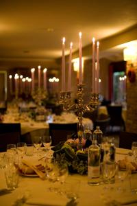 a table with candles on it in a restaurant at Locanda Maison Verte in Cantalupa