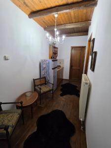 a living room with a table and chairs and a chandelier at Olympia Cozy House in Palaios Panteleimonas