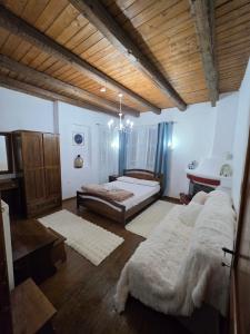 a bedroom with two beds in a room with a wooden ceiling at Olympia Cozy House in Palaios Panteleimonas