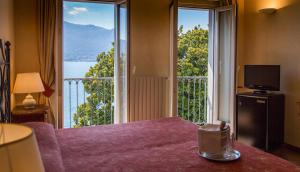 a room with a bed and a large window at Hotel Aquadolce in Verbania