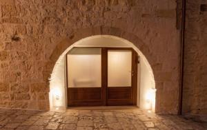 an archway with a wooden door in a stone wall at Arcobaleno in Locorotondo