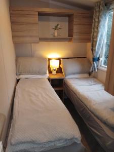 two beds in a small room with a desk at Sunny sands retreat in Skipsea