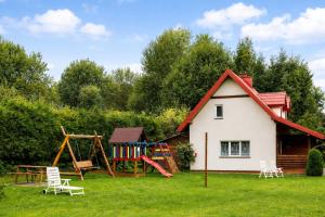 a small house with a playground in the yard at Domki i Pokoje nad Soliną in Polańczyk