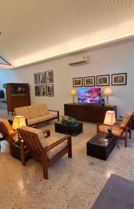 a living room with couches and a flat screen tv at Merdeka House, Bentong in Bentong