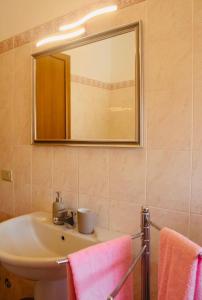 a bathroom with a sink and a mirror and towels at AR House in Clusane sul Lago +8 photos