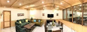 a large living room with couches and a tv at Devdar Heights in Jagatsukh
