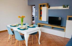 a dining room with a white table and blue chairs at AR House in Clusane sul Lago