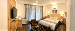 a bedroom with a bed and a desk and a television at Devdar Heights in Jagatsukh