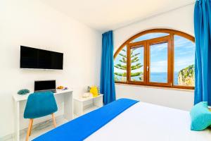 a bedroom with a window and a bed and a desk at Estate4home - Suites Margar in Massa Lubrense