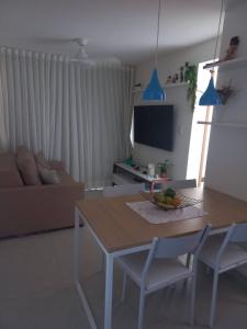 a living room with a table and chairs and a television at Villas House - Praia Formosa - Cabedelo in Cabedelo