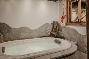 a large bath tub in a bathroom with a window at Gutonhof in Selva di Val Gardena +7 photos
