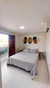a bedroom with a bed and two tables with hats on the wall at Labonita House - Pilar in Itamaracá +63 photos