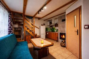 a living room with a couch and a table and a fireplace at Domki i Pokoje nad Soliną in Polańczyk