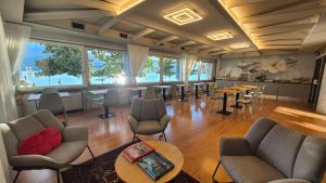 a large room with tables and chairs and windows at Hotel Aquadolce in Verbania +32 photos