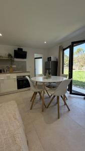 a dining room with a table and chairs in a kitchen at Mazets sous le pin in Le Rouret
