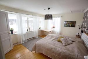 a bedroom with a large bed and windows at Slätterne Gård B&B in Sandviken