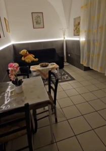 a living room with a table and a teddy bear on a couch at Nonna Ninetta - Locazione Turistica in Orta Nova