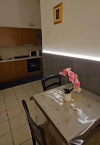 a table with a vase with pink flowers on it at Nonna Ninetta - Locazione Turistica in Orta Nova