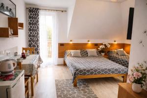a hotel room with two beds and a kitchen at Domki i Pokoje nad Soliną in Polańczyk
