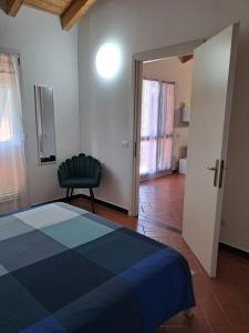 a bedroom with a blue bed and a chair at Casa Cinzia Bonassola Cinque Terre in Bonassola