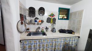 a kitchen counter with a sink and pots and pans at Orlando house in Buritaca +20 photos