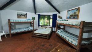 a room with three bunk beds and a window at Orlando house in Buritaca