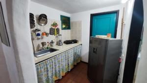 a kitchen with a sink and a refrigerator at Orlando house in Buritaca