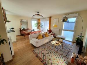 a living room with a couch and a table at Appartement lumineux proche Genève et Jura 3 chambres, terrasses et parking in Gex +10 photos