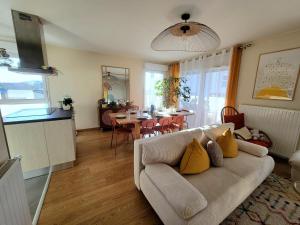 a living room with a couch and a table at Appartement lumineux proche Genève et Jura 3 chambres, terrasses et parking in Gex
