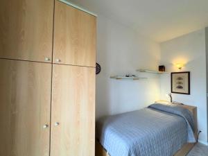a bedroom with a bed and a large wooden cabinet at Riviera Appartament in Grado