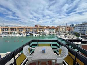 a table and chairs on a balcony with a marina at Riviera Appartament in Grado